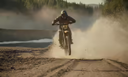 man doing a wheelie on his bike in the dirt
