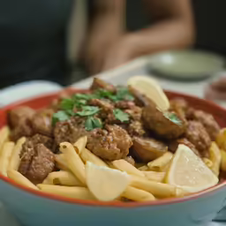 a close up of a bowl with pasta and meat