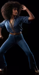 a woman in jeans and shirt standing on a black background