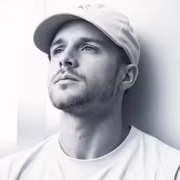 black and white photo of man with baseball cap on