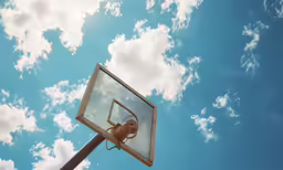 a basketball hoop under a partly cloudy sky
