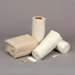 some white items are arranged around each other,several white roll of paper on a table