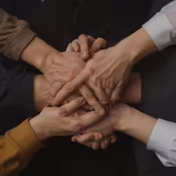there is an image of a group of people putting their hands together