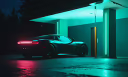 a black sports car in the dark next to a gas station