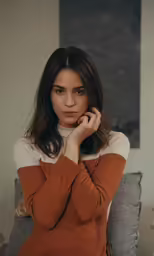 a woman that is sitting down with her hands behind her head