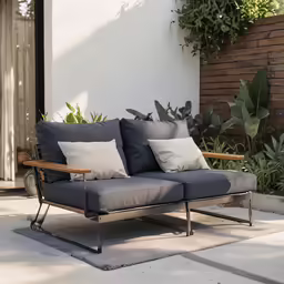 a lounge chair with pillows on it sitting outside