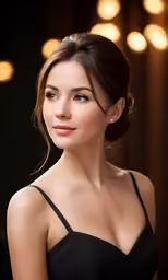 woman in black dress posing for camera with lights behind her