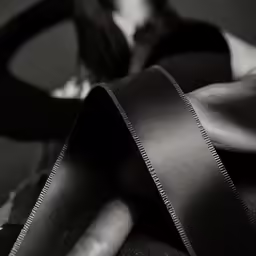 woman holding up her arm with a piece of leather taped to it