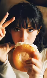 woman in white shirt holding up large donut with one hand