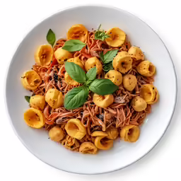 an overhead shot of a dish of noodles with nuts and basil