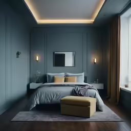 a bedroom with grey walls and wooden floors, a large bed with grey sheets, a bench with stool and a window on the side, and a yellow stool in front
