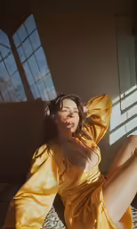 a young woman is sitting on a bed and posing for the camera