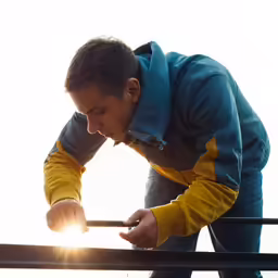 man on the sun going down from his trip looking at his cell phone