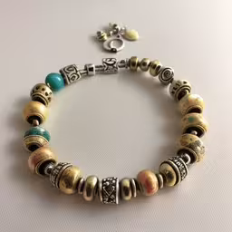 bracelet with two beads and a cross,a bracelet with beads, and a charm