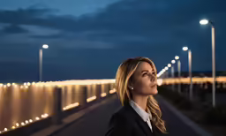 a woman standing outside in front of several lights
