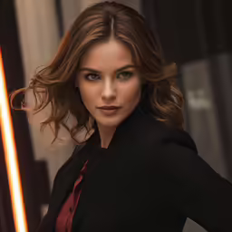 a woman in a suit and tie is posing for a picture