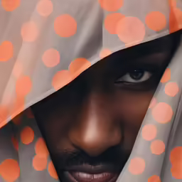 a black person with a orange polka dotted covering his head
