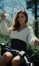 the woman is riding her bike outside holding an object