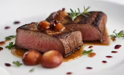 steak on a plate with some garnish and nuts