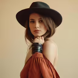 a woman posing for the camera wearing a hat and dress shirt