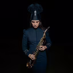 the woman is playing on the saxophone in a dark room
