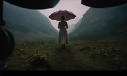 a woman with a red umbrella walks through some hills