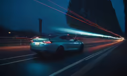 a white car driving on the road at night