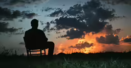 the silhouette of a man is sitting on a bench