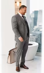 a man in a gray suit looking at his bag