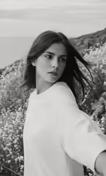 a woman posing for a portrait near flowers