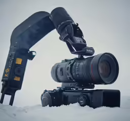 camera equipment attached to large piece of equipment on top of snow