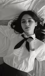 a woman laying on a bed under a comforter