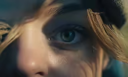 a close up of a womans face, with light from her eyes