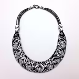 a black and white necklace with beads,a black and white necklace with two beads on it,this necklace has an intricately designed design on it,a black and white necklace that is on a table,a very pretty black and white necklace