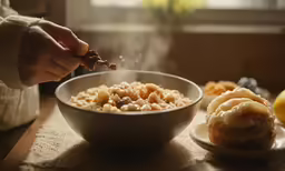 a person holding food in front of a bowl of food