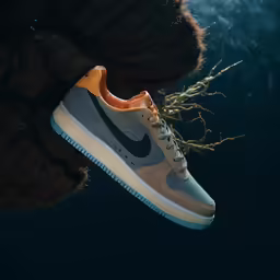a pair of sneakers is hanging off of the side of a wall