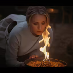 a woman with a burning skillet in her hands