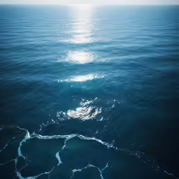 an aerial shot of blue ocean water with a circle