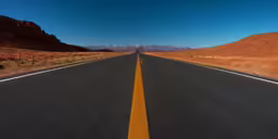 a road with yellow lines between two mountains