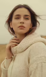 a woman is standing with her hands on her shoulder and her head is up, in the air