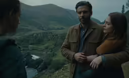 a man and woman with one hand around the shoulders, are looking away