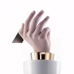 a white vase with a gold band and a white hand holding a small container
