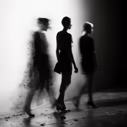 three women walk in a foggy room together