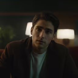 a young man is looking at the camera