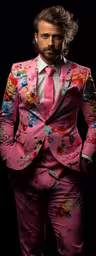 a male in a pink suit standing and looking at the camera,a man with a pink suit and tie