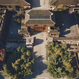 a building surrounded by some trees and trucks