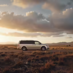 a van traveling down a road with clouds in the background