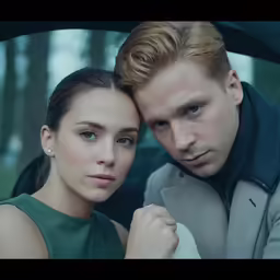 a young couple are in the back seat of a car