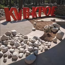 a sign with rocks and sand in the foreground