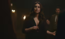 the actress in a black dress standing next to a man